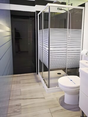 A modern bathroom with a glass shower enclosure, a toilet, and a bidet. - Studio Apartment 'Ofis - Estudio Negro' with Wi-Fi and Air Conditioning (Conil de la Frontera)