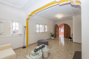A spacious interior with a high ceiling, a glass coffee table with decorative items, and a potted plant. - 4-Bedroom Villa El Romero—Private Pool, BBQ & Relaxation (Arucas)