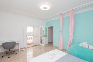 Habitació d'hotel amb llit, escriptori, cadira i porta del bany.