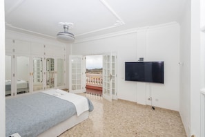 A bedroom with a bed, wardrobe, and a TV mounted on the wall. - 4-Bedroom Villa El Romero—Private Pool, BBQ & Relaxation (Arucas)