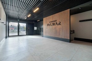 Eine großzügige Lobby mit modernem Design, mit einem gut sichtbaren 'Grand Bylwar'-Schild an der Wand.