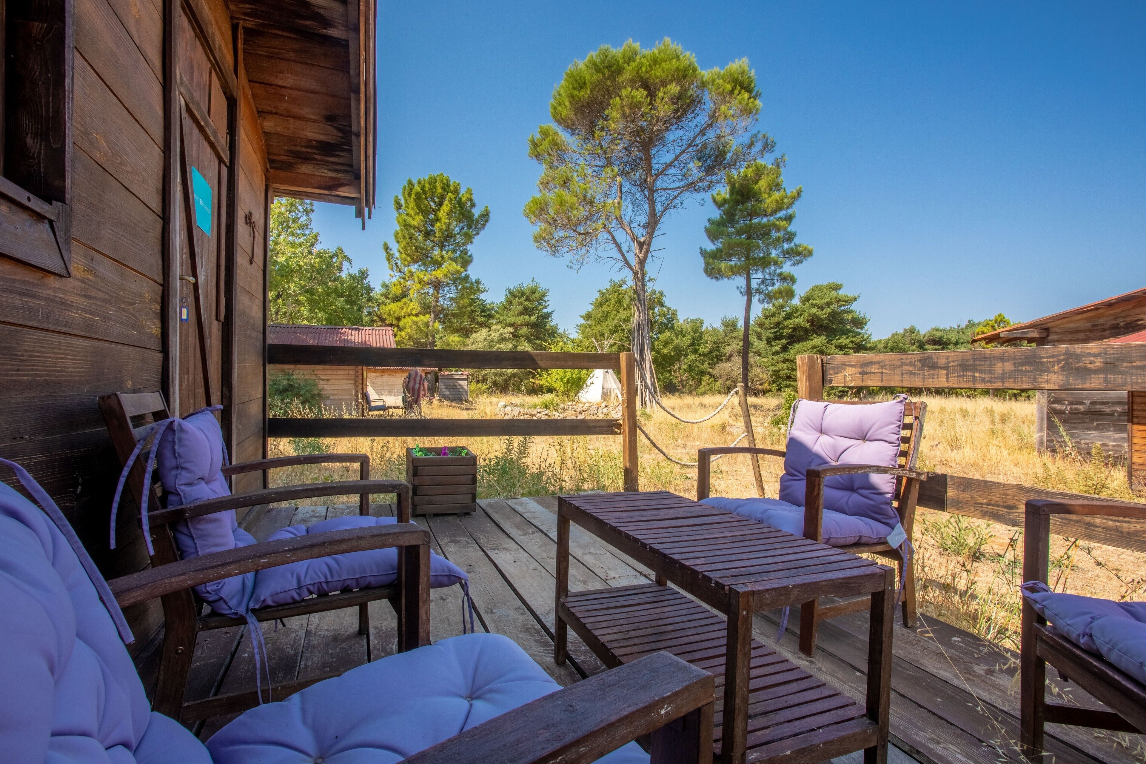 Une terrasse en bois avec des sièges extérieurs et une vue sur un paysage naturel.
