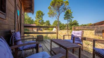 Une terrasse en bois avec des sièges extérieurs et une vue sur un paysage naturel.