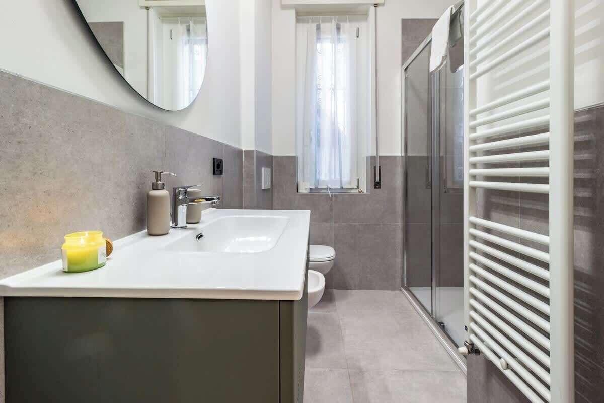 Une salle de bain moderne avec un double lavabo, des toilettes et une douche à parois de verre.