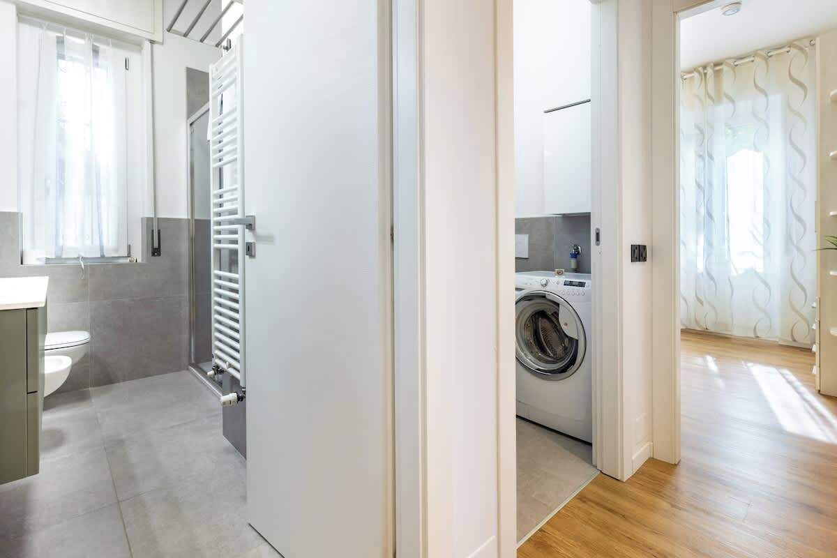 Un baño moderno con inodoro, lavamanos y zona de ducha.