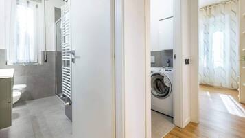 Un baño moderno con inodoro, lavamanos y zona de ducha.