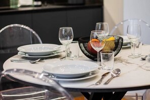 A dining table set with plates, glasses, and cutlery, with a decorative bowl and a clear glass pitcher. - luxury house - como lake - [parcheggio interno] (Como)
