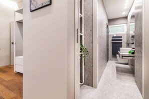 A narrow hallway leading to a bathroom with a sink and a mirror. - luxury house - como lake - [parcheggio interno] (Como)