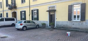 Eine Straße mit einem parkenden Auto und einem Gebäude mit Tür und Fenstern.