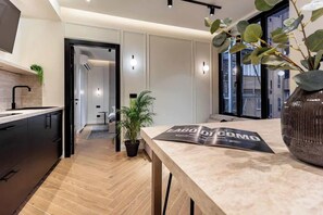 A modern kitchen with a wooden countertop, a potted plant, and a magazine on the table. - [Lungolago] Nuovo Bilocale 1 (Como)