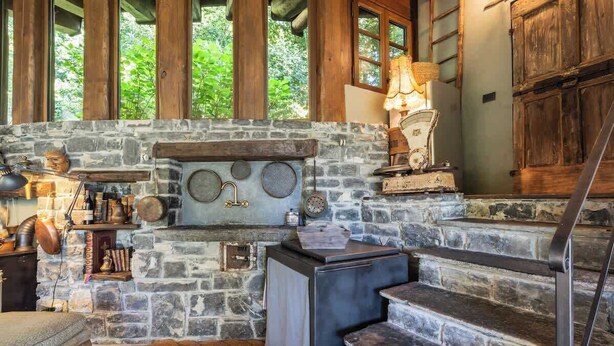 A rustic interior with a stone fireplace, wooden staircase, and a cozy seating area. - Private Villa Pied en l'eau [Only by Boat] (Riva)