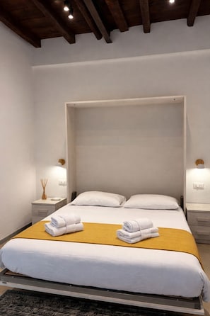 A modern hotel room with a bed, two bedside tables, and a headboard. - [Borgovico] Modern Romantic Como Central Apt (Como)