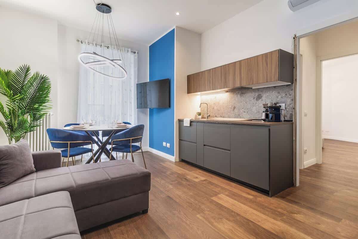 A modern kitchen with dark cabinets, a countertop, and a built-in stove.