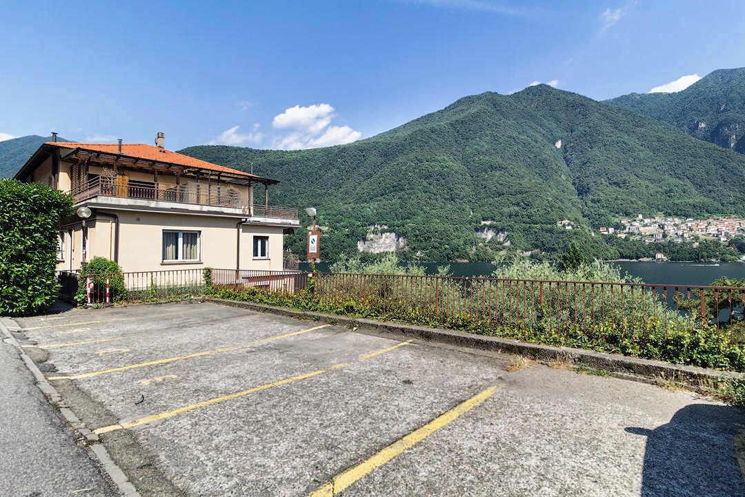 Ein Gebäude mit Parkplatz und Blick auf einen See und Berge.