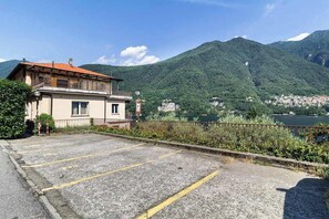 A building with a parking area and a view of a lake and mountains.