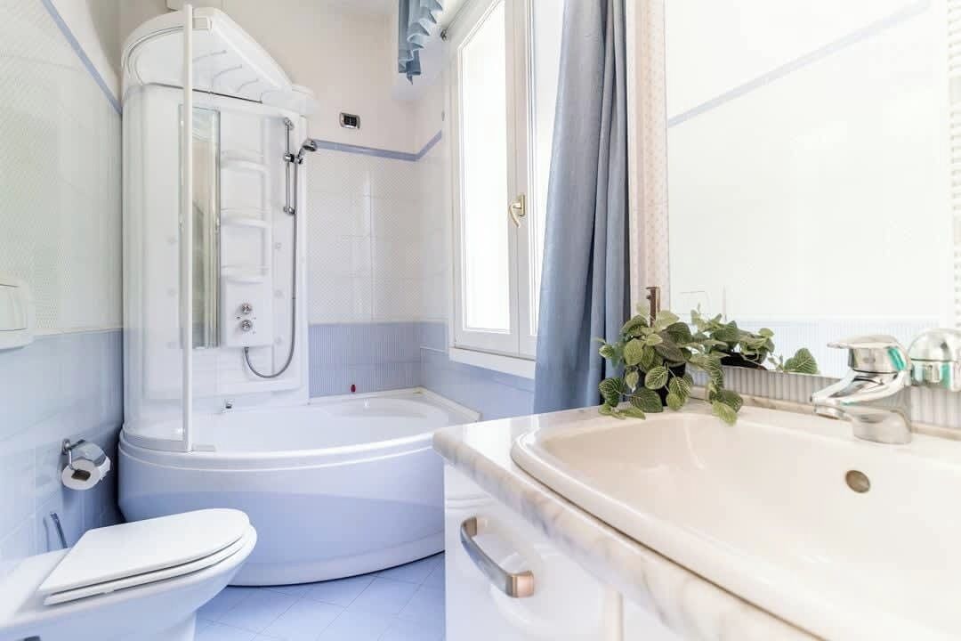 Un bagno con doccia, wc e lavandino.