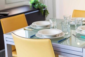A dining table set with plates, glasses, and cutlery.