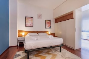 Ein Hotelzimmer mit Bett, Nachttischen und Kunstwerken an den Wänden.
