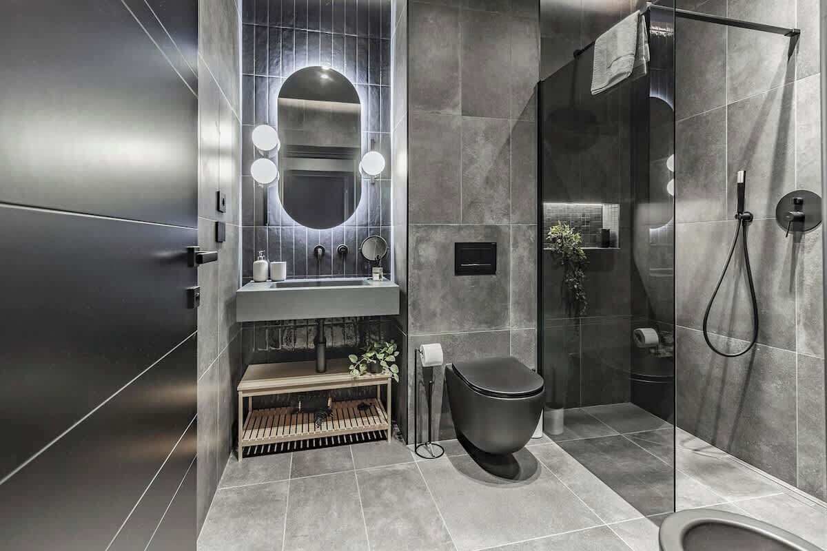 A modern bathroom with a large mirror, a toilet, and a shower area.