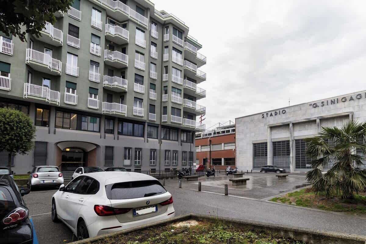 Un immeuble résidentiel à plusieurs étages, doté de balcons et d’un espace de stationnement.