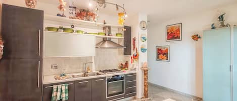 Eine moderne Küche mit Backofen, Edelstahlgeräten und Dekorationen auf den Regalen.