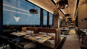 A restaurant interior with high ceilings, modern lighting, and a view of the cityscape. - Grand Fiesta Americana Riviera Cancún All Inclusive (Puerto Morelos)