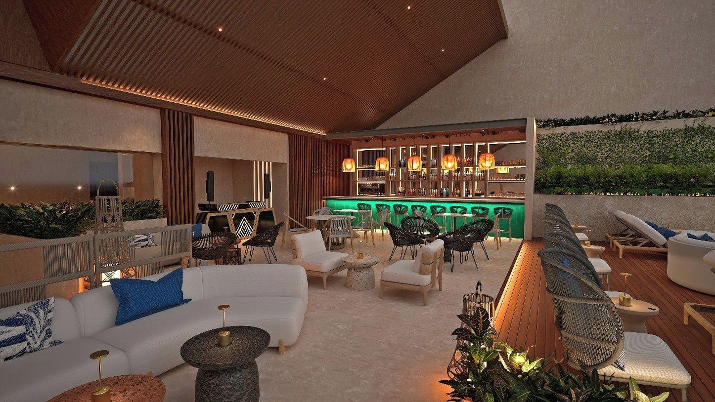 An outdoor lounge area with seating, a bar, and a view of greenery.