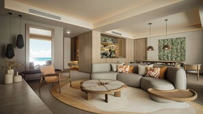 A modern living room with a sectional sofa, a round coffee table, and a dining area with a view of the ocean. - Grand Fiesta Americana Riviera Cancún All Inclusive (Puerto Morelos)