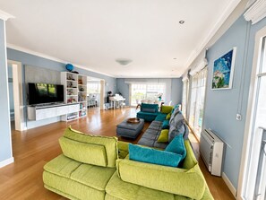 A spacious living room with a large flat-screen TV, a piano, and a sofa set. - Five-bedroom villa on Cap d'Antibes (Juan les Pins Antibes)