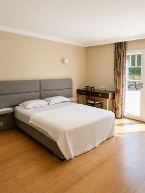 Ein Schlafzimmer mit einem Bett, Nachttischen, einem Schreibtisch und einem Sessel.