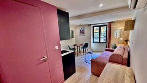 Et moderne interiør med en røddør, et spiseområde med stole og et bord, samt en sofa.