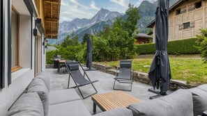 A patio with outdoor seating, a barbecue grill, and a view of mountains. - Chalet Elsa - renovated 4 bedroom chalet with a Jacuzzi & sauna in les Houches (Les Houches)