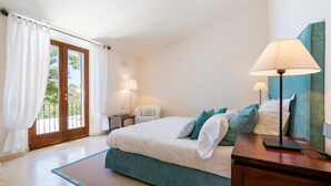 A bedroom with a bed, bedside tables, a chair, and a lamp. - Son Polvell, Finca 5StarsHome Mallorca (Andratx)