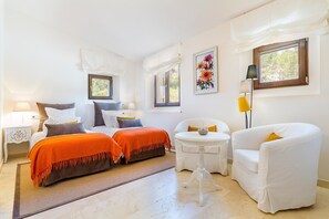Ein Zimmer mit einem Bett, zwei Stühlen, einem kleinen Tisch und einem Fenster.
