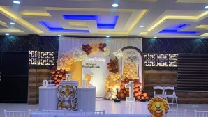 A stage with a birthday theme, including balloons, a cake, and a lion decoration. - Odyssey Rendezvous (Kunnathunad)
