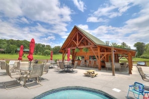 A wooden gazebo with a pool and outdoor seating area. - UndHrvstMoon: Pool, HotTub, Wifi, Theater, Games, Pets, OutdoorFireplace (Sevierville)