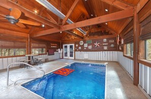 Ein Holzinnenraum mit Pool, Deckenventilator und einer Sitzgelegenheit im Freien.
