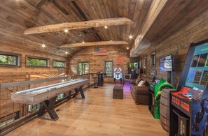 Ein Holzambiente mit Billardtisch, Spielautomaten und Jukebox.
