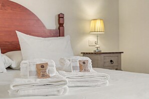 A neatly made bed with folded towels and a bottle of shampoo. - House 'Casa Clarita Tindaya' with Historic Charm and Views (Tindaya)