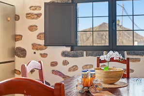 A dining table with a wooden bowl, a potted orchid, and packaged food items. - House 'Casa Clarita Tindaya' with Historic Charm and Views (Tindaya)