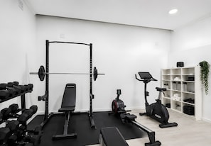 A gym with a squat rack, bench press, dumbbells, an elliptical, and a treadmill. - Room 'Suite King 1' with Mountain View, Shared Pool and Wi-Fi (Alviobeira)