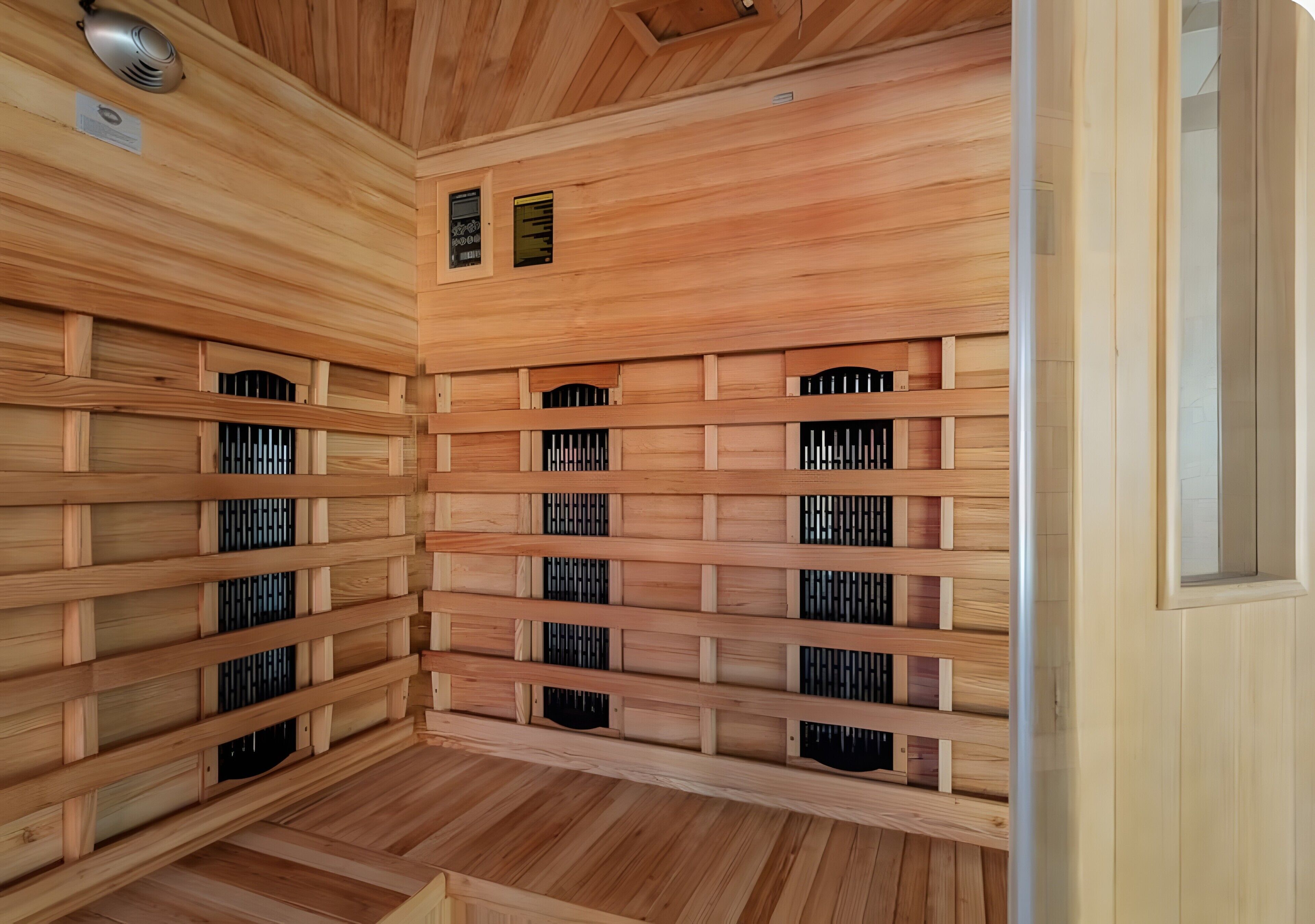 A sauna with wooden walls and benches, ventilation slots, and a ceiling vent.