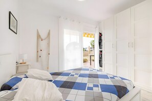Un dormitorio con cama, mesita de noche, lámpara de pared y armario.