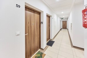A hallway with wooden doors, numbered 59, and a fire extinguisher on the wall.