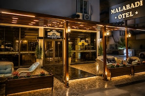 Exterior de l'Hotel Malabadi, amb façana moderna, grans finestres de vidre i zona d'aigües obertes.