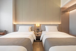 A hotel room with two beds, a bedside table with a lamp, and a wall-mounted control panel. - Poltton International Apartment (Liuzhou Yaobu Ancient Town Panlongshan) (Shantou)