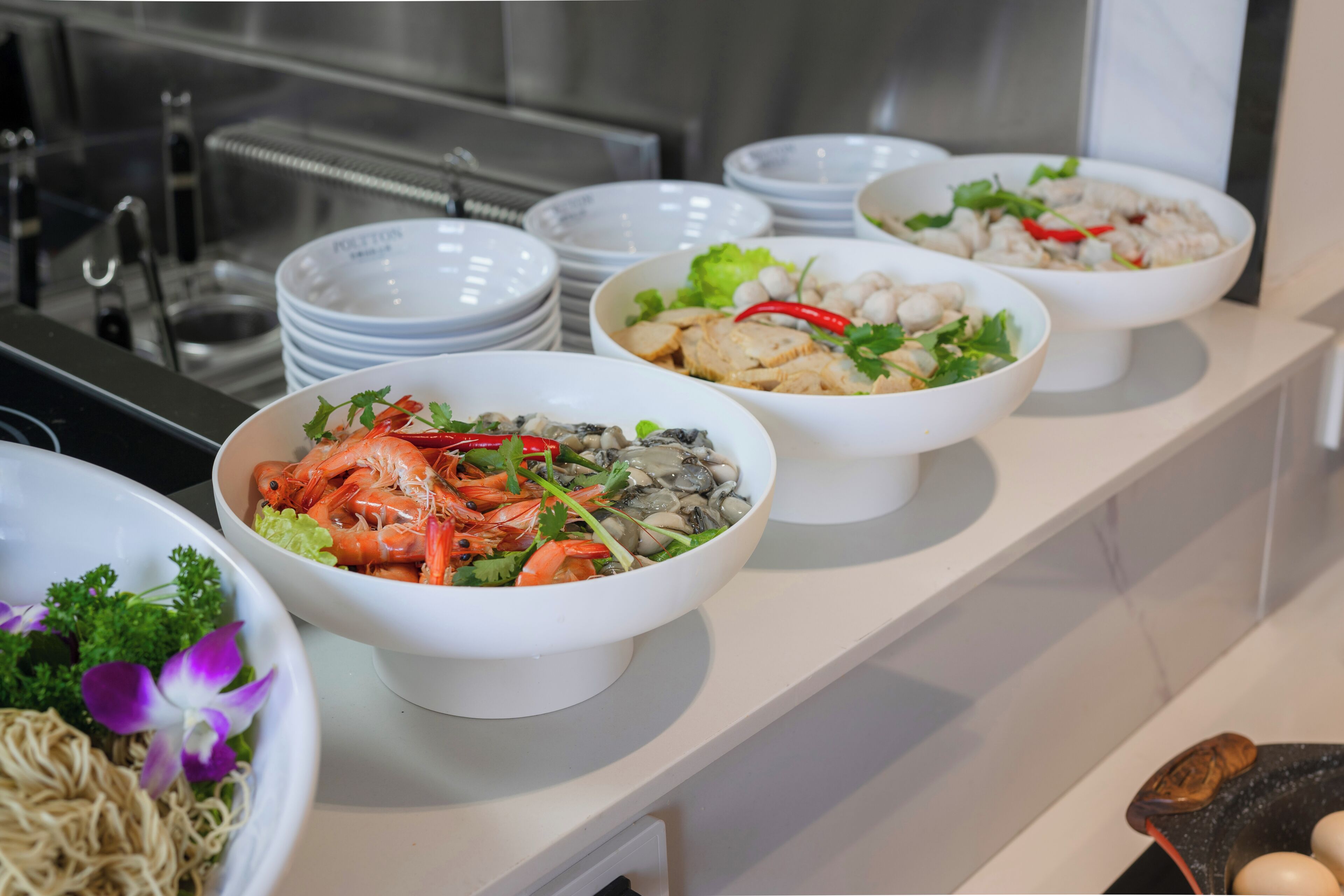 A buffet with various dishes including seafood, vegetables, and noodles.