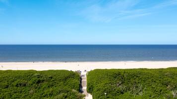 Een strand met een heldere lucht, een zandstrand en een pad dat naar het strand leidt.