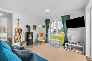 Een moderne woonkamer met een bank, een open haard, een boekenkast en een televisie.