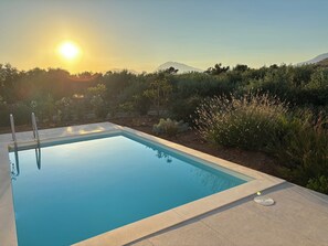 Une piscine rectangulaire à l’eau d’un bleu limpide, entourée d’une terrasse carrelée.